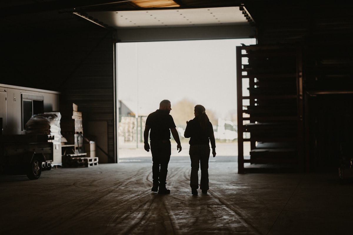 A man and a woman walking into a garage