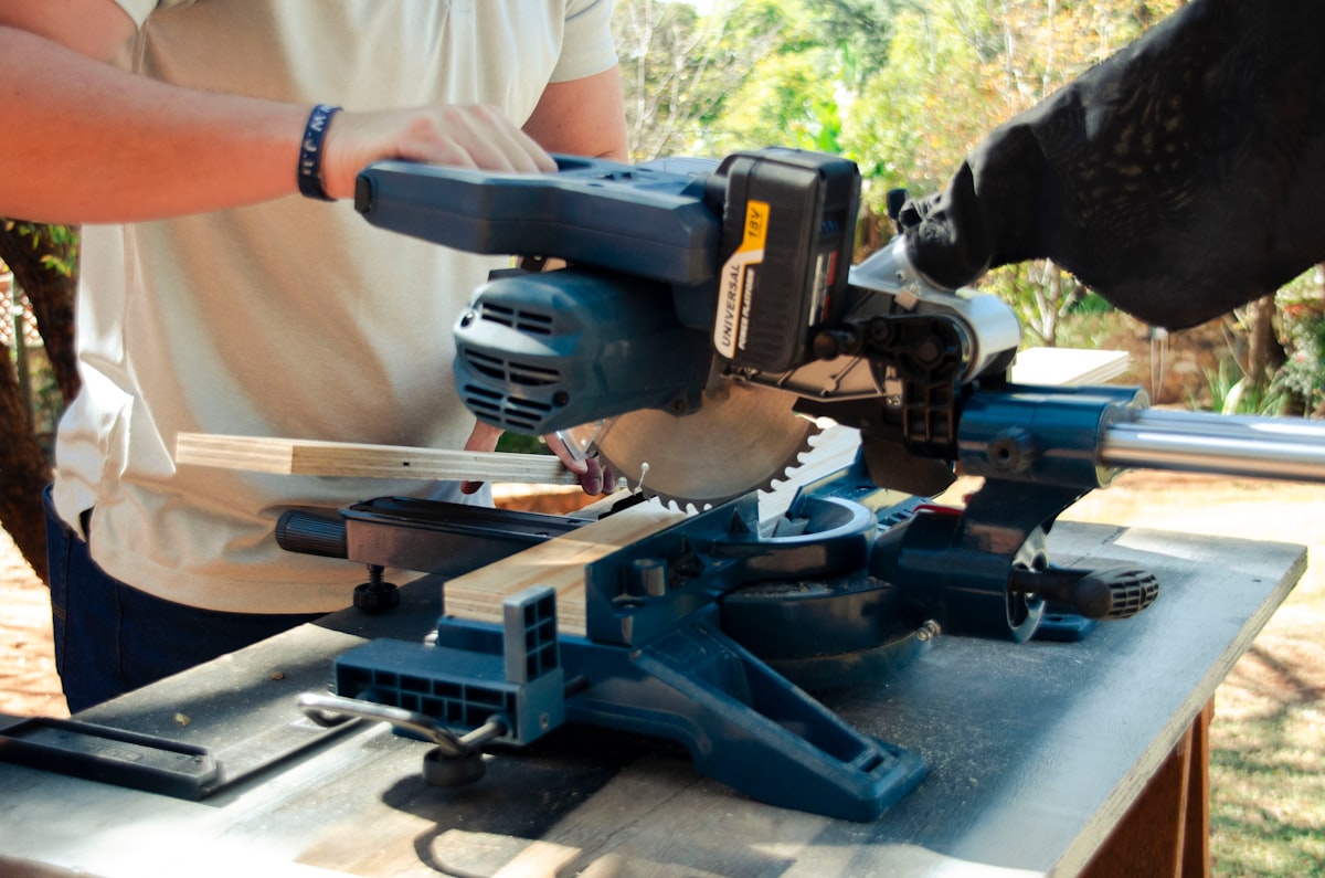 A man using a table saw to cut a piece of wood