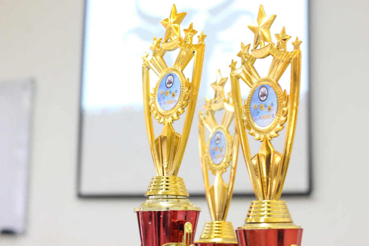 Two red and gold trophies sitting on top of a table