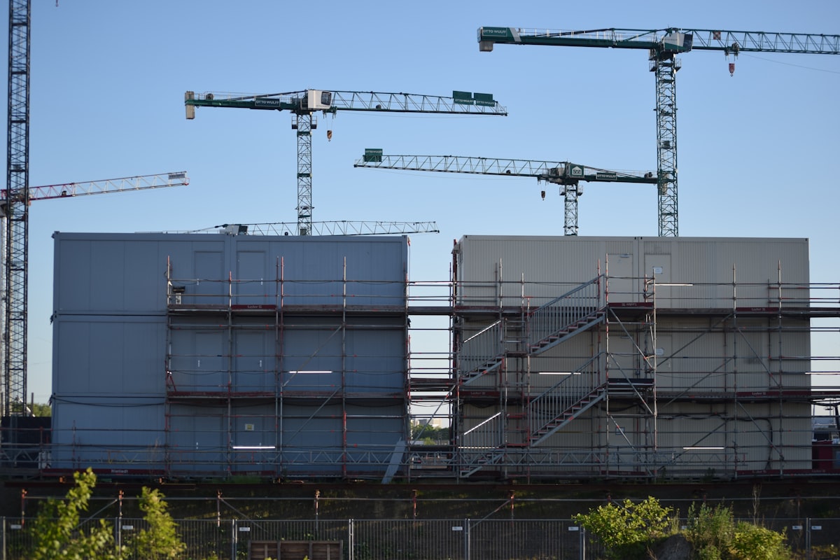 A bunch of cranes that are next to a building